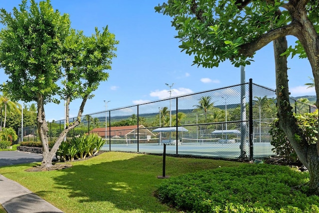 view of tennis court with a lawn