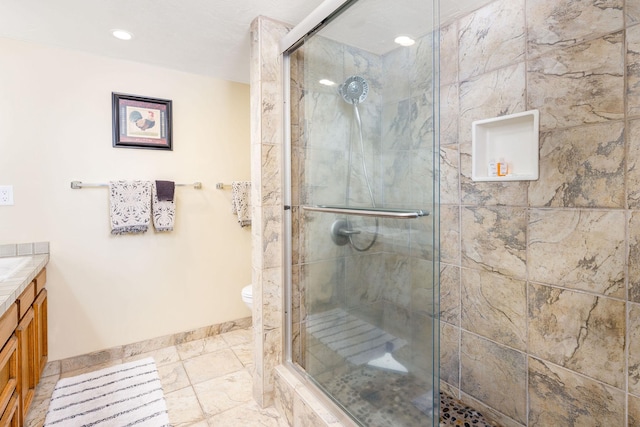 bathroom with vanity, toilet, and a shower with door