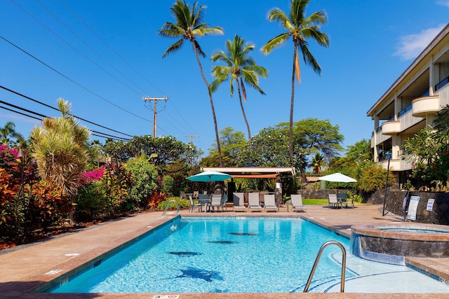 view of swimming pool featuring a community hot tub and a patio