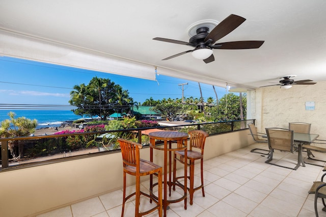 balcony featuring a water view and ceiling fan