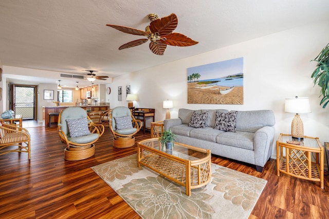 living room with hardwood / wood-style flooring, a textured ceiling, and ceiling fan