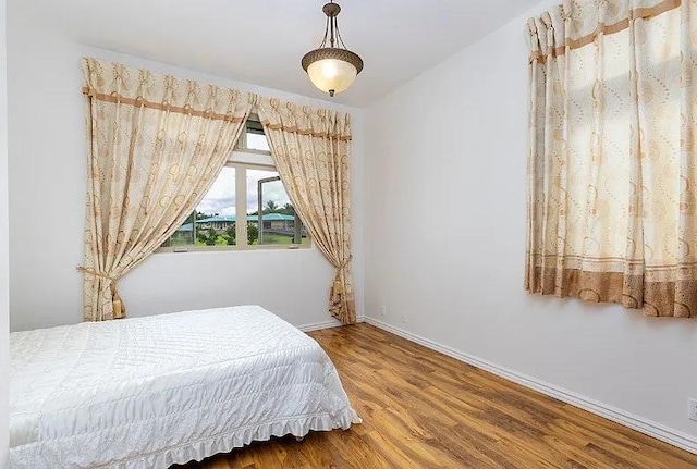 bedroom featuring baseboards and wood finished floors