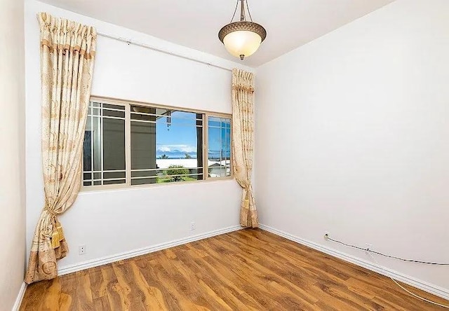 unfurnished room featuring baseboards and wood finished floors