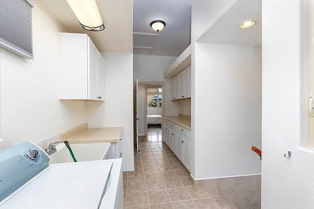 laundry room featuring washer / dryer, cabinet space, a sink, and light tile patterned floors