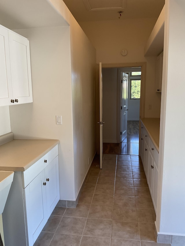 hall featuring light tile patterned floors and baseboards