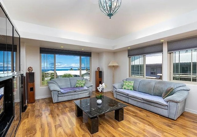 living area with baseboards and wood finished floors