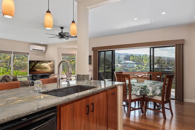 kitchen featuring sink, dishwasher, hanging light fixtures, light stone counters, and a wealth of natural light