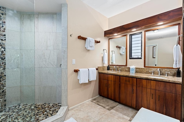 bathroom featuring vanity, tile patterned flooring, and tiled shower