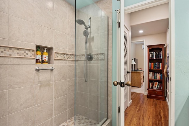 bathroom featuring hardwood / wood-style floors and a tile shower