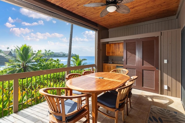 sunroom / solarium with a water view, ceiling fan, and wood ceiling