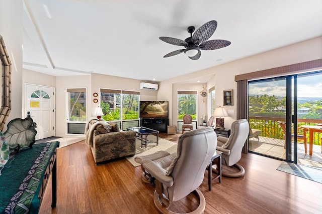 living room with wood-type flooring, a wall mounted AC, and ceiling fan