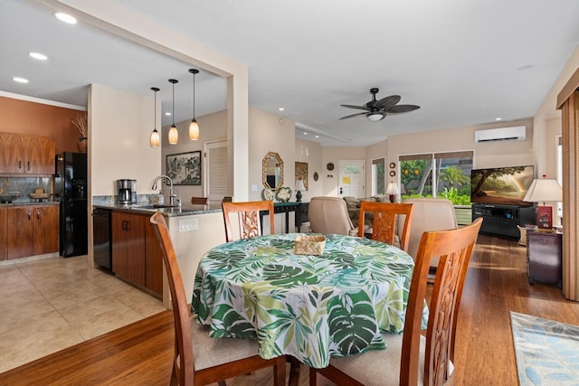 tiled dining room with ceiling fan, a wall mounted air conditioner, and sink