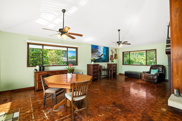 dining space with ceiling fan, dark parquet flooring, and lofted ceiling