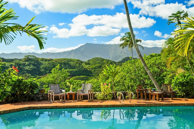 view of pool featuring a mountain view and a patio area