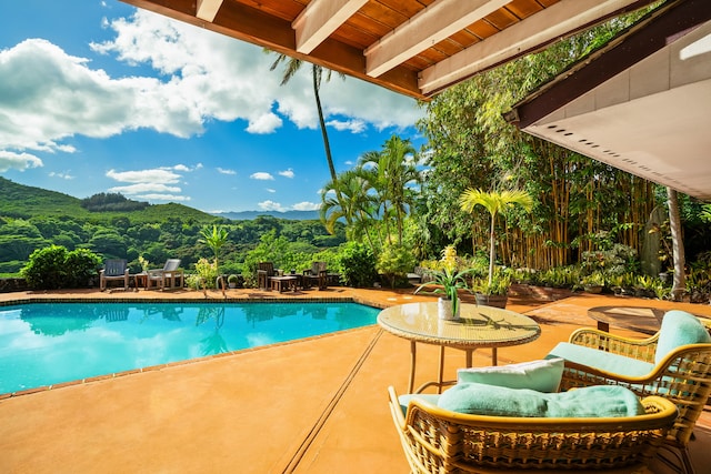 view of pool featuring a mountain view and a patio area