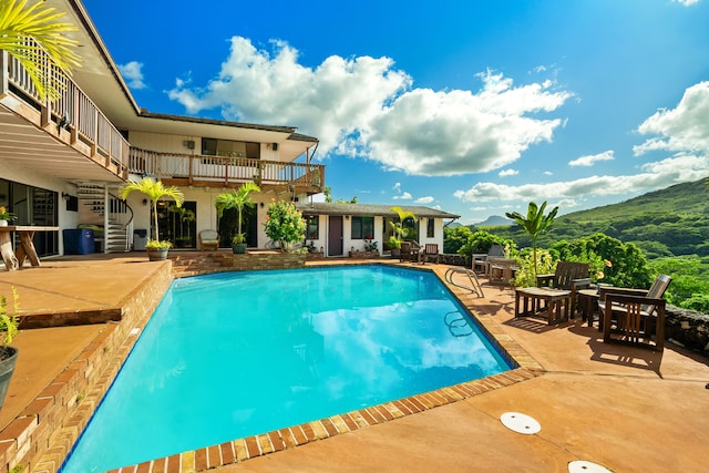 view of swimming pool with a mountain view and a patio