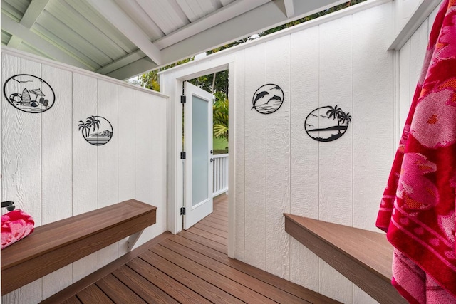 mudroom with vaulted ceiling with beams, hardwood / wood-style flooring, and wooden walls