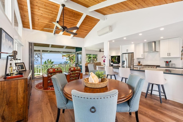 dining space with beamed ceiling, wood ceiling, a wall unit AC, and light hardwood / wood-style floors