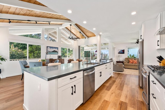 kitchen with appliances with stainless steel finishes, vaulted ceiling with beams, sink, white cabinets, and wood ceiling