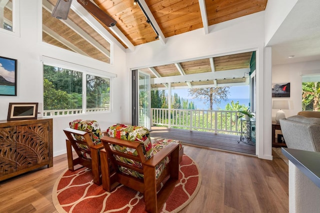 sunroom with lofted ceiling with beams, plenty of natural light, and wood ceiling