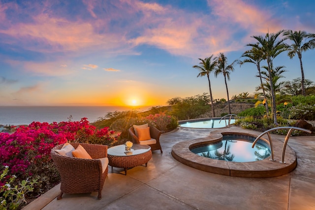 patio terrace at dusk with a pool with hot tub and a water view