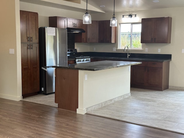 kitchen featuring pendant lighting, a center island, stainless steel refrigerator, light wood-type flooring, and stove