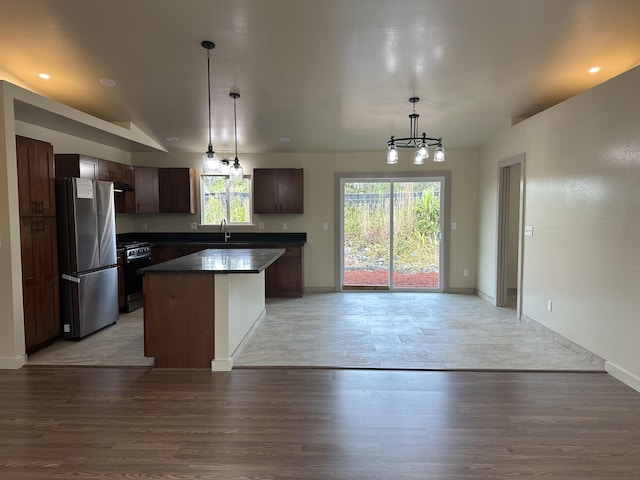 kitchen with light hardwood / wood-style floors, pendant lighting, a center island, and stainless steel refrigerator