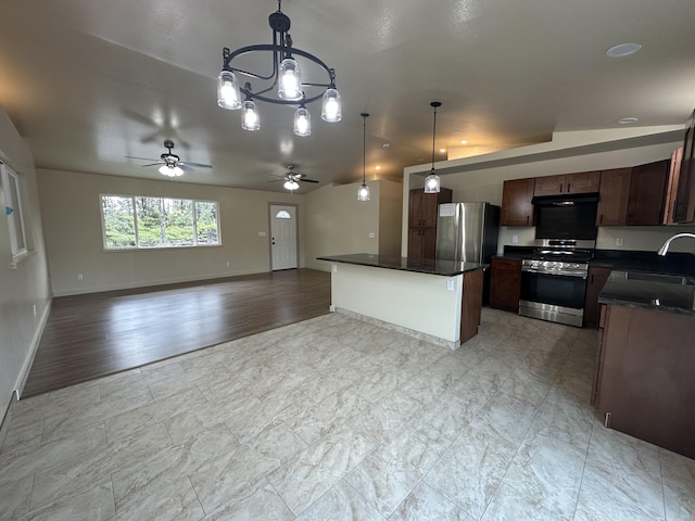 kitchen with decorative light fixtures, ceiling fan with notable chandelier, stainless steel appliances, and a kitchen island