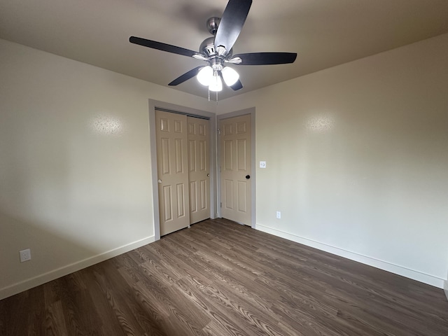 unfurnished bedroom featuring dark wood-type flooring and ceiling fan