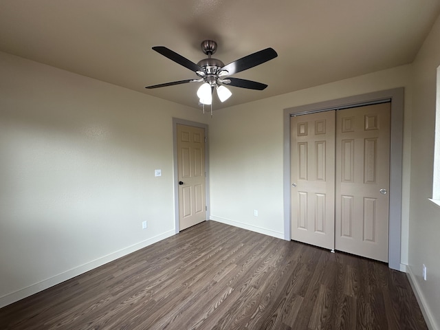 unfurnished bedroom featuring ceiling fan, a closet, and dark hardwood / wood-style flooring