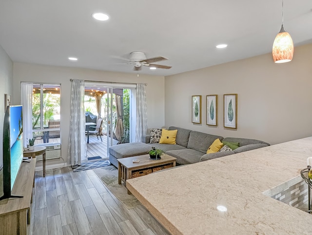 living room with ceiling fan and light wood-type flooring