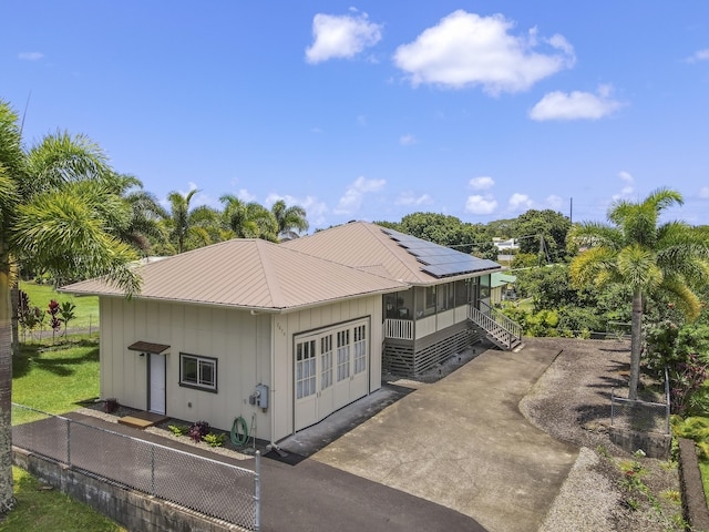 exterior space with a sunroom and solar panels