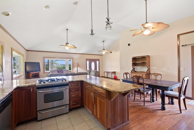 kitchen featuring light stone counters, kitchen peninsula, stainless steel appliances, and vaulted ceiling