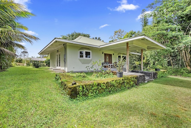 rear view of property featuring a lawn and a porch