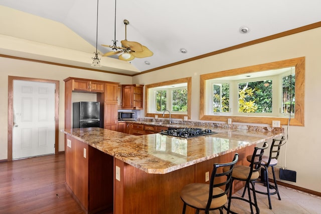 kitchen featuring black appliances, sink, vaulted ceiling, ceiling fan, and light stone counters