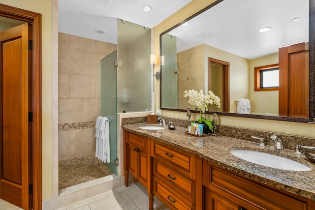 bathroom with tiled shower, a sink, and tile patterned floors