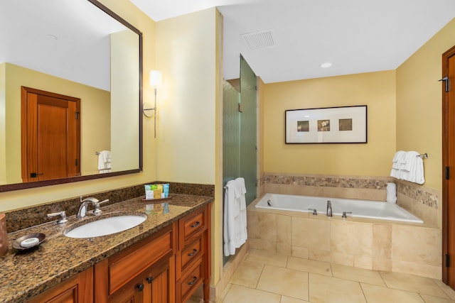 bathroom featuring tile patterned flooring, visible vents, a garden tub, and vanity