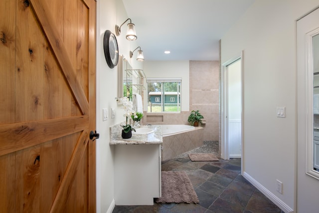 bathroom with vanity and tiled bath