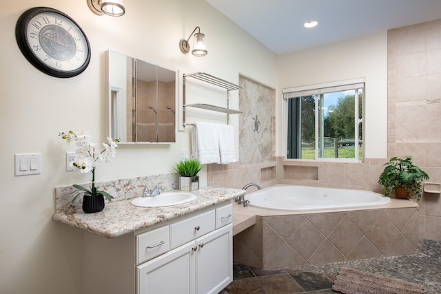 bathroom featuring vanity and tiled tub