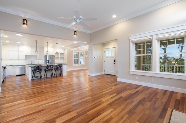 unfurnished living room featuring ceiling fan, light hardwood / wood-style flooring, and crown molding