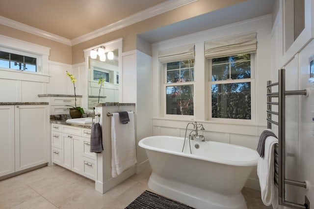 bathroom with tile patterned floors, a bath, crown molding, and vanity