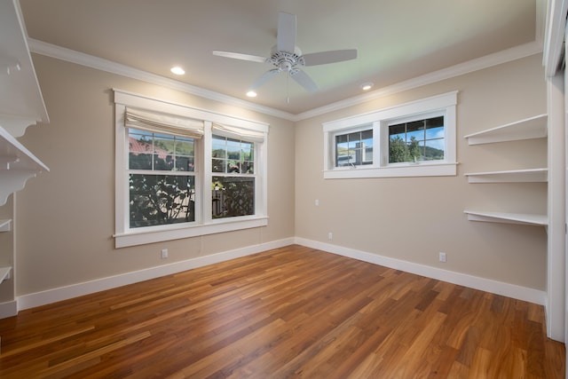 empty room featuring ceiling fan, crown molding, and wood-type flooring