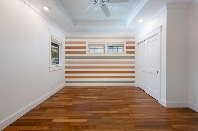 hallway featuring crown molding, dark hardwood / wood-style floors, and a tray ceiling