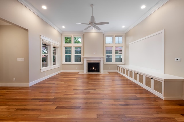 unfurnished living room featuring ceiling fan, hardwood / wood-style floors, and crown molding