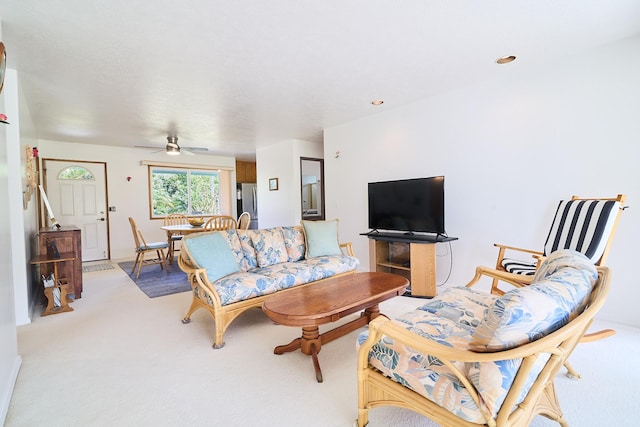 carpeted living room with ceiling fan