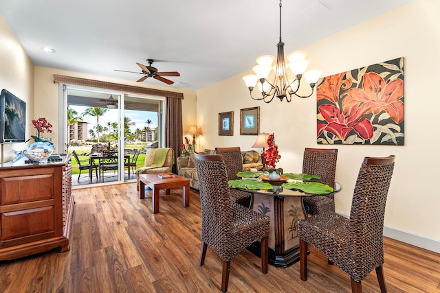 dining room featuring wood-type flooring and ceiling fan with notable chandelier