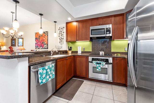 kitchen with stainless steel appliances, an inviting chandelier, sink, hanging light fixtures, and kitchen peninsula