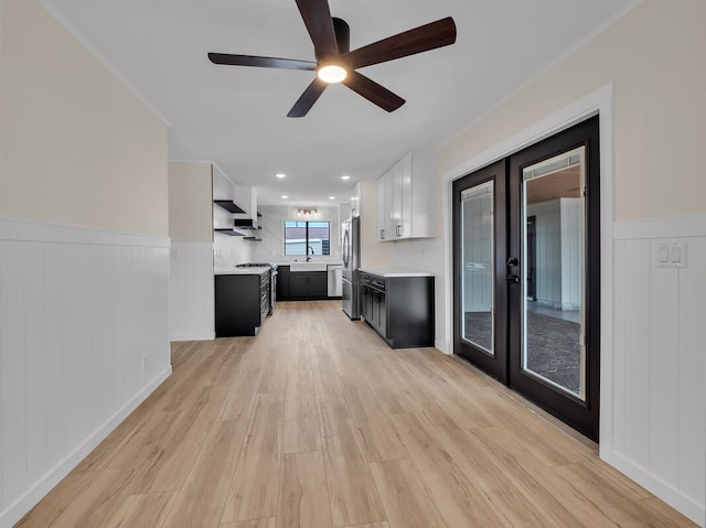 unfurnished living room with french doors, ceiling fan, light hardwood / wood-style flooring, and sink