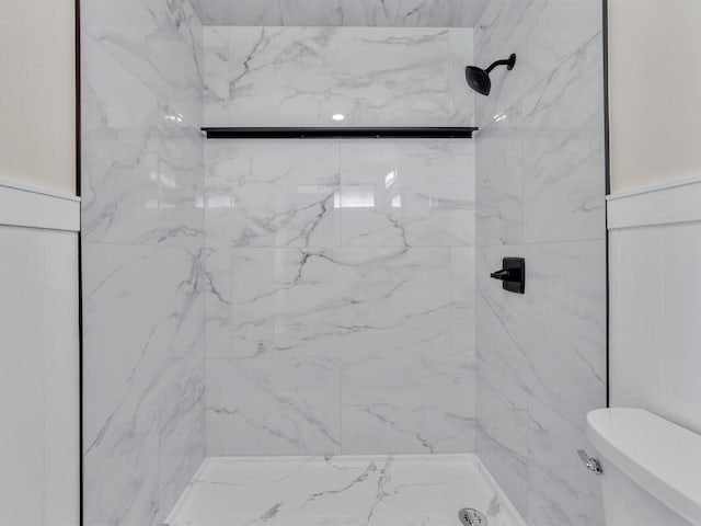 bathroom featuring a tile shower and toilet