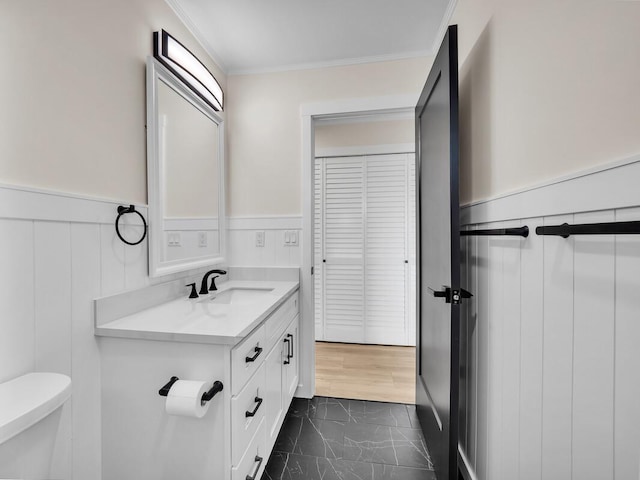 bathroom with toilet, ornamental molding, and vanity